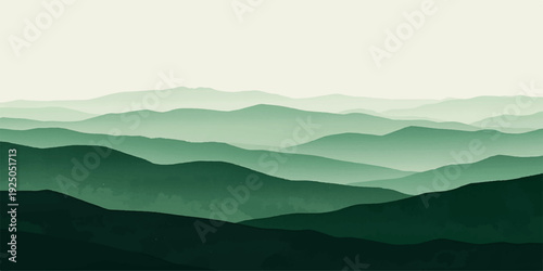 Misty morning view of a blue mountain range landscape with clouds and fog at sunrise over a forest valley.