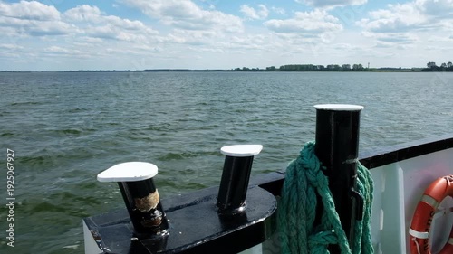 View over the railing of a ship towards the sea and the coast