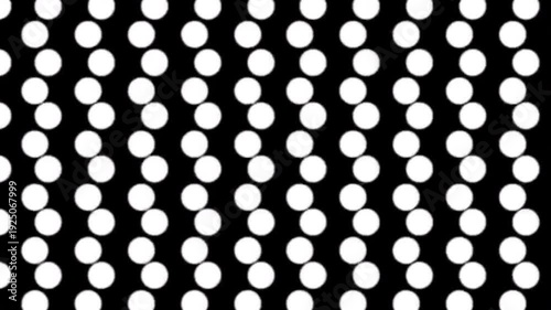 Seamless loop of white polka dots moving diagonally across a black background for motion graphics.