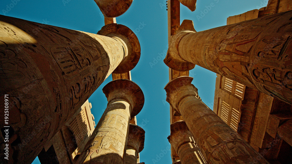 Naklejka premium Ancient columns of Karnak Temple in Luxor Egypt viewed from below at sunset