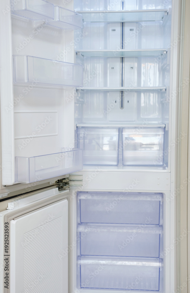 Fototapeta premium Modern open refrigerator close-up with empty shelves, front view.