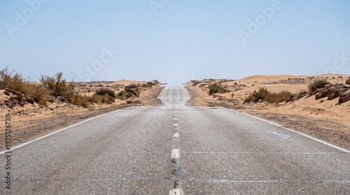 Desert road shimmering under intense heat, disappearing into the horizon