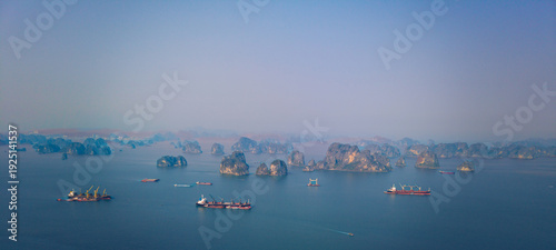 Billede på lærred Aerial view of Halong bay's limestone islands and cargo ships and tanker at sunr