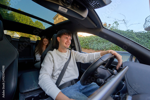 Принти на полотні Young couple enjoying road trip driving car with sunroof