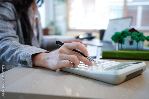 Business mortgage realtor with house model, sitting at desk, real estate agent manager working on calculator and documents, mortgage and property