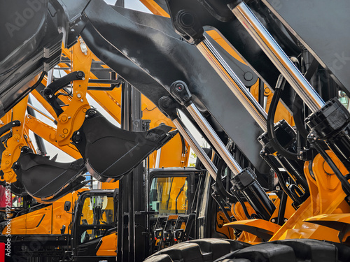 Construction equipment lined up at a dealership showing loaders and excavators ready for work in the afternoon sun
