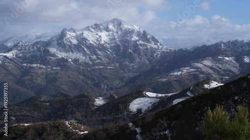 A breathtaking aerial view of the lush green mountains and traditional architecture in San Martin de Rey Aurelio, Asturias, Spain.