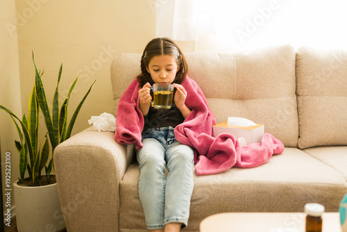 Quadro em tela Sick little girl feeling unwell, recovering from illness at home, drinking herba