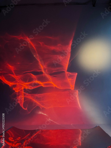 Vibrant abstract light patterns on a reflective liquid mirror surface in a studio, created with colored lighting