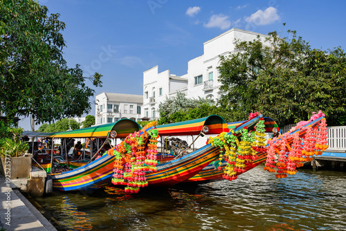 Bangkok, Thailand - A khlong or channel of the Chao Phraya River with colorful longtail wooden boats and traditional residential buildings in Bangkok