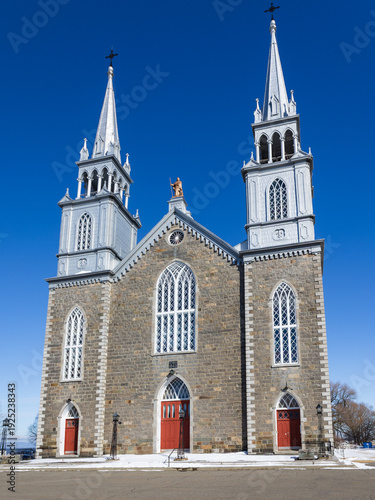 Vertical view of the facade of the Neo-Gothic 1849 Saint-Roch stone church, Saint-Roch-des-Aulnaies, Québec, Canada