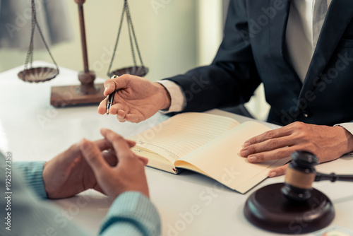 Valokuva The lawyer is pointing out the signature points on a legal document with a pen during a legal consultation meeting, representing the client in court and assisting with legal documents