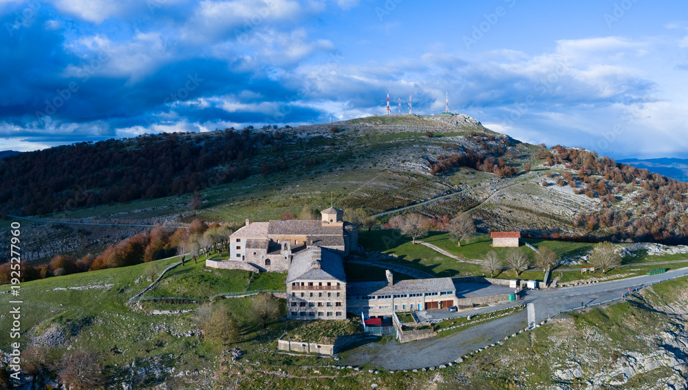 Fototapeta premium Aerial drone view of the autumn landscape surrounding the beech forest and the Sanctuary of San Miguel de Excelsis in the Sierra de Aralar. Huarte-Araquil, Navarre, Spain, Europe