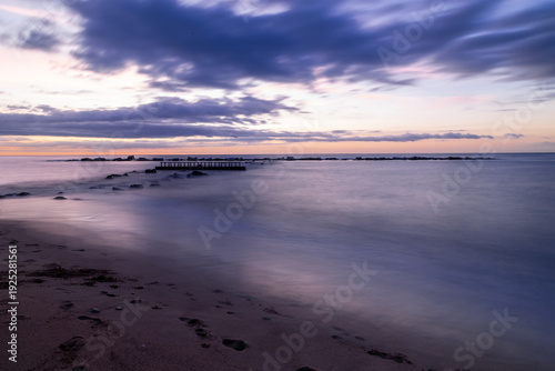 Amazing colourful sunrise seen over the Mediterranean Sea from Barceloneta Beach, which is located next to Barcelona's classic fishing quarter. It is the cities oldest and best-loved beach and gives w