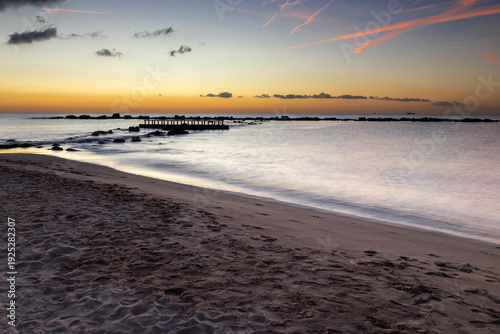 Amazing colourful sunrise seen over the Mediterranean Sea from Barceloneta Beach, which is located next to Barcelona's classic fishing quarter. It is the cities oldest and best-loved beach and gives w