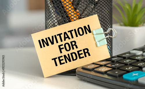 Obraz na plátně INVITATION FOR TENDER text on a craft card with a binder clip near a calculator on an office desk