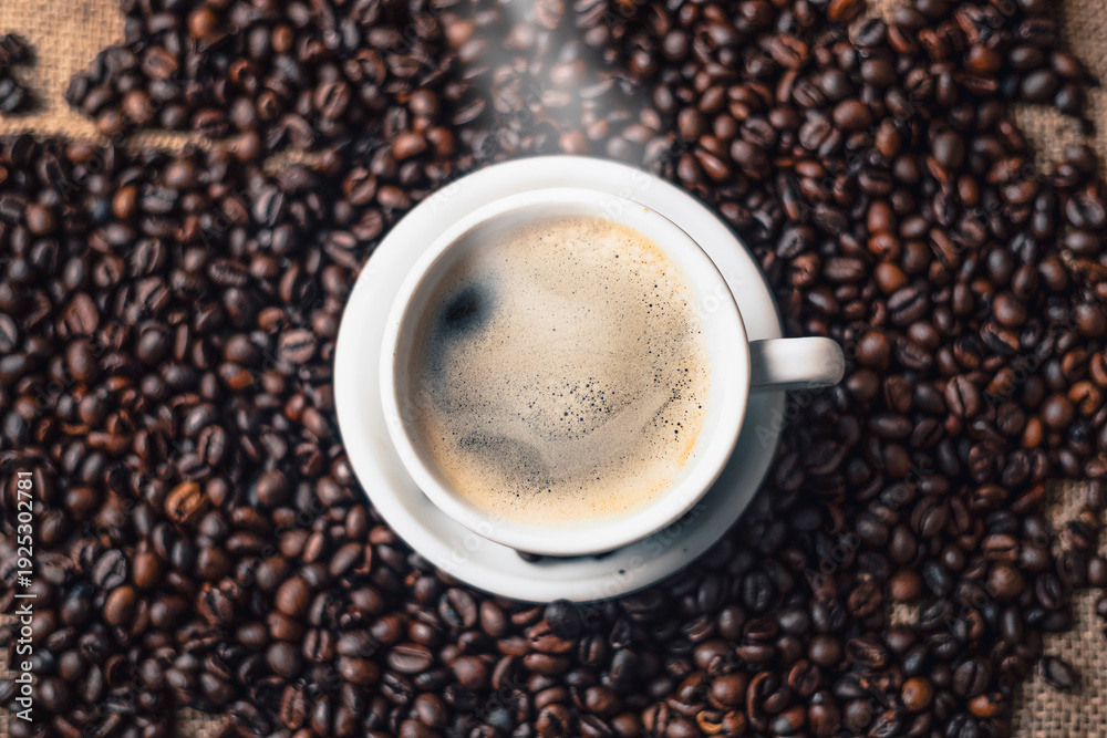 Fototapeta premium Steaming Coffee Cup Surrounded by Roasted Beans