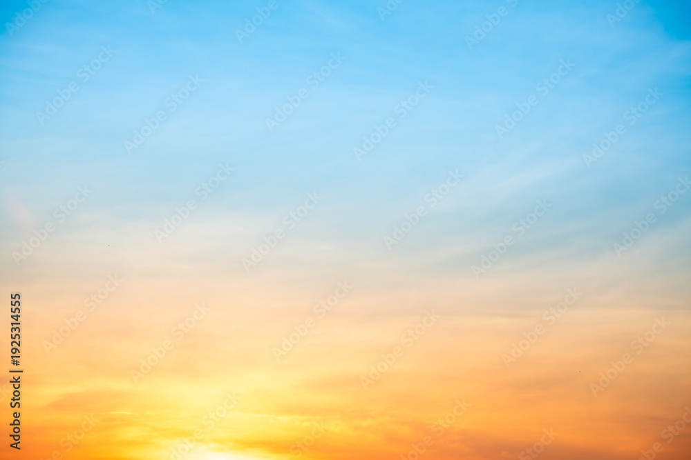 Fototapeta premium Sunset or sunrise sky with a vibrant gradient of orange, gold, and soft blue. Clear atmosphere with wispy clouds. Peaceful, natural light background. hope, freedom, new day and inspirational Concepts