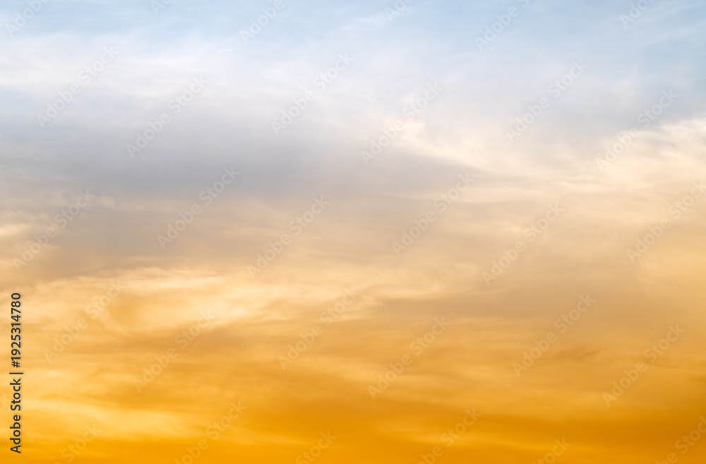 Obraz premium Sunset or sunrise sky with a vibrant gradient of orange, gold, and soft blue. Clear atmosphere with wispy clouds. Peaceful, natural light background. hope, freedom, new day and inspirational Concepts
