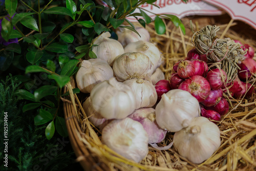 A rustic basket filled with fresh garlic bulbs and purple shallots, showcasing natural textures and earthy tones, perfect for cooking, food photography, and adding rich flavor to homemade dishes.