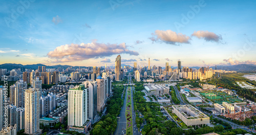 Quadro su tela Aerial view of the modern Shenzhen skyline and city center with skyscraper and green park under a clear blue sky at sunset, China