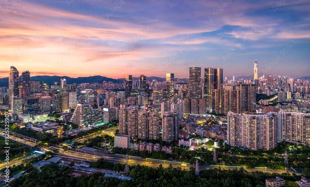 Fototapeta premium Modern skyscrapers and urban skyline glowing at sunset in Shenzhen, China.