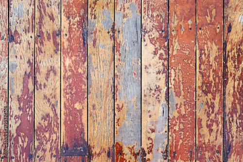 Quadro em tela A close-up view of weathered wooden floorboards with peeling paint in warm shades of red, orange, and yellow, revealing layers of aged texture beneath