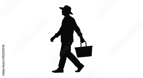 A dark silhouette of a man walking with a basket captured in a simple striking profile silhouette