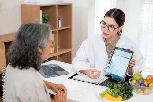 Asian nutritionist showing AI meal plan on tablet to senior patient, digital health technology consultation for personalized nutrition, diet control and medical wellness of elderly in clinic.