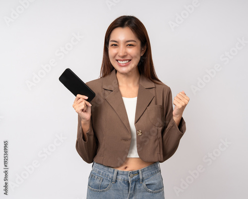 Pretty young asian woman using cellphone standing on isolated white background. Happy Excited Beautiful young asian shopping online payment with mobile phone. Playing game on smartphone