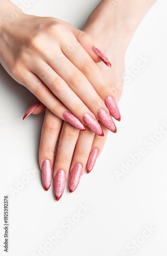Female hands showing long pink glitter stiletto nails
