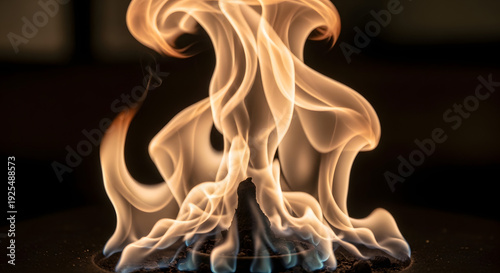 Vibrant flames rising from a dark base, illustrating a fiery spectacle in a dimly lit environment, viewed from a close-up perspective