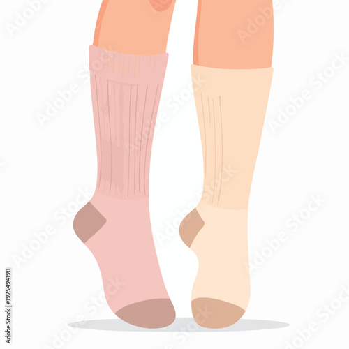Pair of legs wearing different colored knee-high socks standing on tiptoes