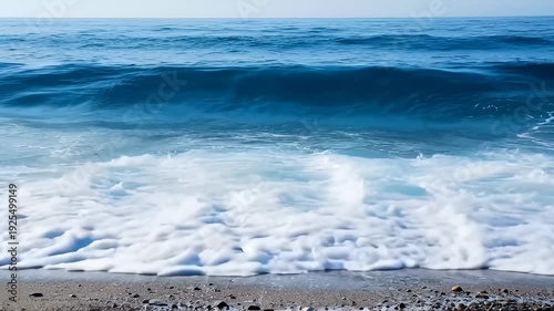 Powerful Ocean Wave Crashing on Shore With White Foam and Pebbles
