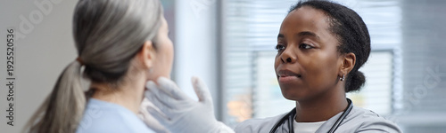 Canvastavla Website header shot of Black young adult woman examining face and neck of Caucas