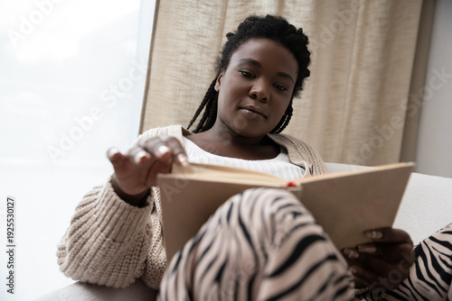 Relaxing in a cozy apartment while enjoying a good book in the afternoon