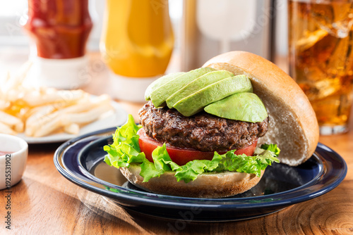 ファストフード店の木目テーブルに置かれたアボカドバーガー