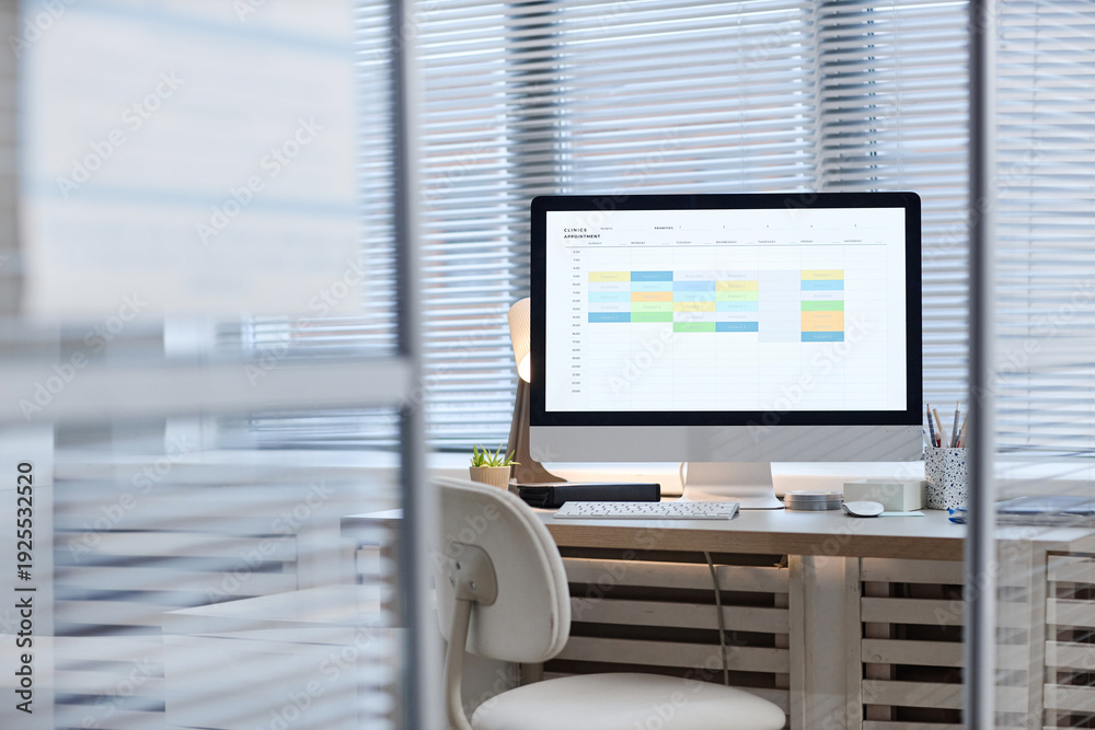 Fotografie Modern office workspace featuring desktop computer displaying digital calendar w