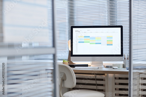 Fotografie Modern office workspace featuring desktop computer displaying digital calendar w