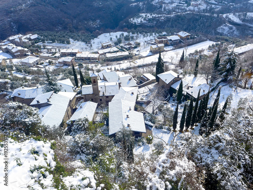 Fotografie View from Sompriezzo of the snow-covered roofs of Musio