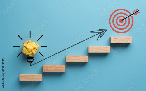 Crumpled Idea Lightbulb, Ascending Steps, and Target with Arrow on Blue Background Representing Business Goal Achievement.