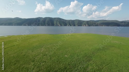 A lake in a national park in summer, birds flying over the water, filmed with a drone
