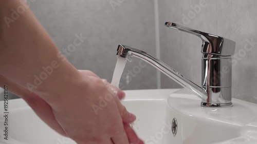 washing hands with soap in a white sink