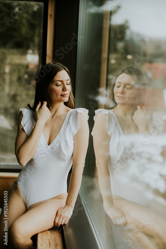 Woman in white swimsuit pos...