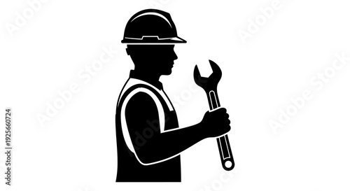 A silhouetted worker wearing a hard hat and holding a wrench in his hand high quality