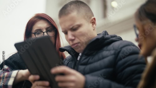 Wallpaper Mural A young woman and man focus on a digital tablet together outdoors. They are sharing information and collaborating on a task. Torontodigital.ca