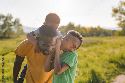 Foto A single father shares joyful moments with his sons in a park during sunset
