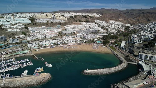 Puerto Rico - Gran Canaria - Wyspy Kanaryjskie - Hiszpania - plaża i architektura turystycznej miejscowości nagrane dronem.