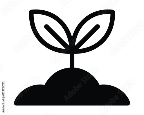 Seedling sprout grows from dark soil mound.