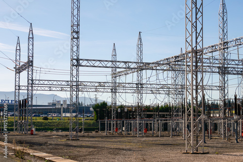 Pamplona, Spain - February 23, 2026. An open-air electrical substation, with multiple metal lattice structures, suspended cables, insulators and high-voltage equipment, located in an industrial area 